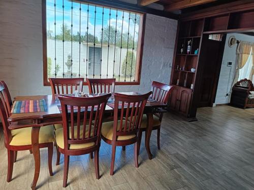 a dining room with a table and chairs and a window at Beautiful country house in Latacunga in Pujilí