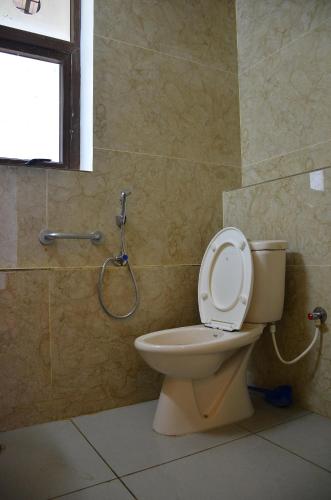 a bathroom with a toilet and a shower at ARYASREE homestay in Kodaikānāl