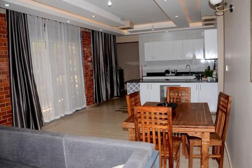 a kitchen and dining room with a table and chairs at Molten terzie in Kampala
