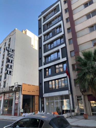 a tall building on a city street with cars parked in front at Tk Residence in Izmir