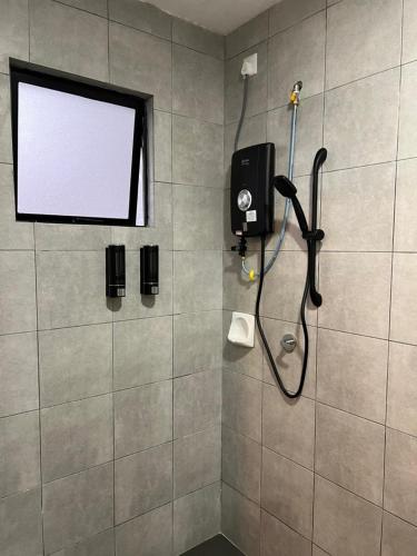 a bathroom with a shower with a shower head at Highland Chill Retreat in Tanah Rata