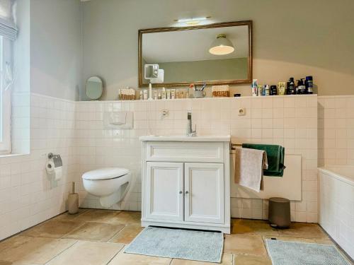 a bathroom with a sink and a toilet and a mirror at Historic Railway Cottage At Mount Arber in Bayerisch Eisenstein