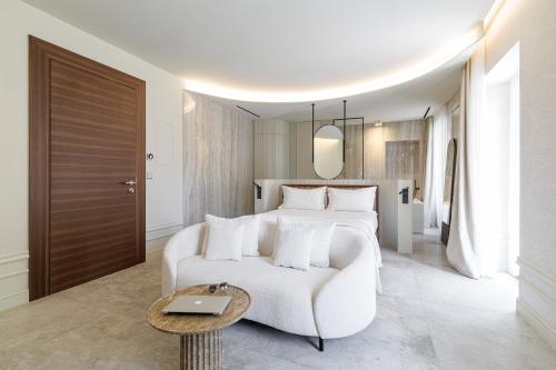 a bedroom with a white bed and a white couch at Le Dortoir Boutique Suites in Nice