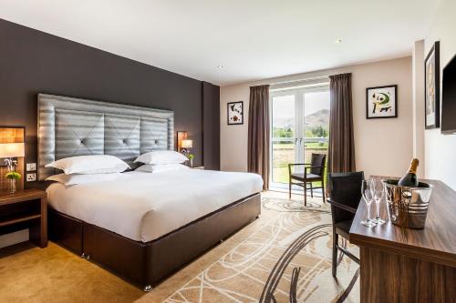 a large bedroom with a large bed and a desk at The Daffodil Hotel & Spa in Grasmere