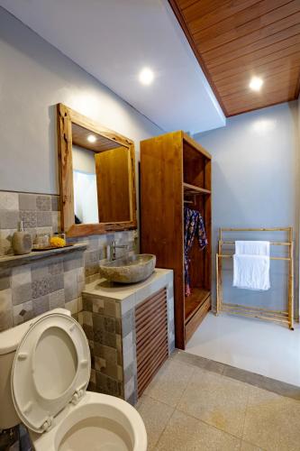 a bathroom with a toilet and a sink at Poset Unique Inn in Ubud