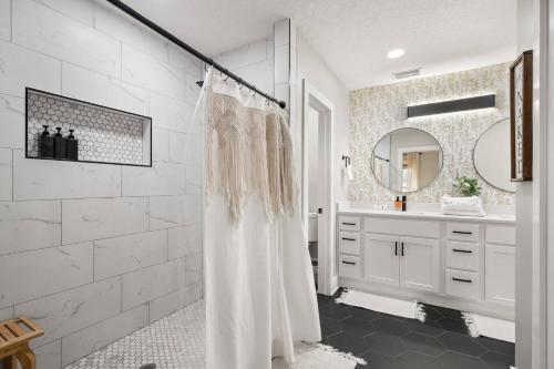 een witte badkamer met een douchegordijn en een wastafel bij Historic 4BR Home centrally located in Riverside. in Jacksonville