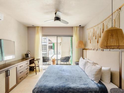 a bedroom with a bed and a desk and a television at Tulum City Apartments Bakal C in Tulum