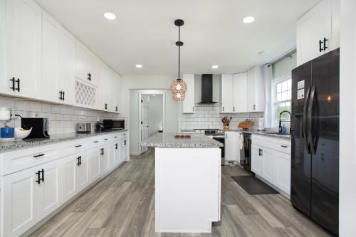 a kitchen with white cabinets and a black refrigerator at Cozy Corner Spacious Area Outdoor Lounges in Knoxville