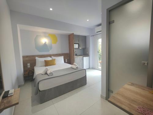 a bedroom with a bed with white sheets and yellow pillows at Corfu Port Studios in Mantoúkion