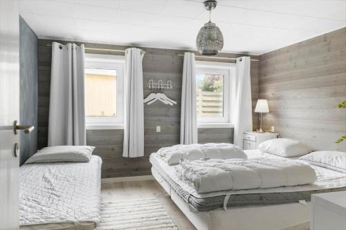 two beds in a bedroom with two windows at TV1552-Jerup-Badhusvej-3 in Jerup