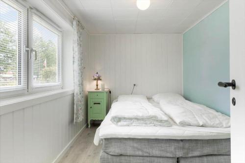 a white bedroom with a bed and a window at TV1552-Jerup-Badhusvej-3 in Jerup