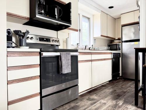 a kitchen with white cabinets and black appliances at Dream Lakefront Escape + Beach/Ski/Golf near NYC in Highland Lakes