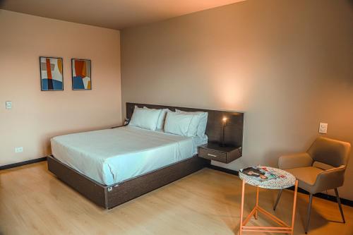 a small bedroom with a bed and a chair at Tequendama Hotel Medellín - Estadio in Medellín