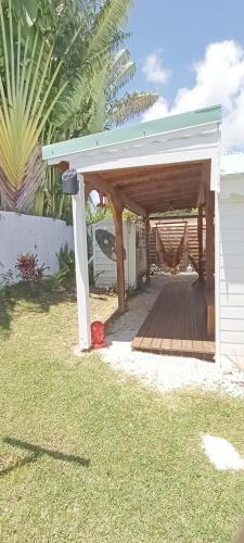a wooden pergola with a deck in a yard at Kaz'bouchons in Saint-François