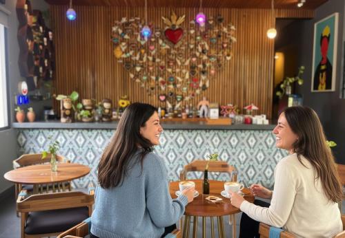 two women sitting at a table in a restaurant at Casa Chukum - Hotel Boutique in Bacalar
