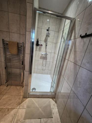 a shower with a glass door in a bathroom at Walk from East Croydon Train Station in South Norwood