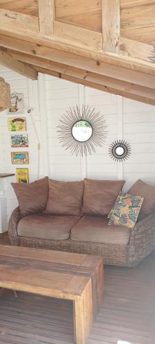 a living room with a brown couch and a ceiling at Kaz'bouchons in Saint-François