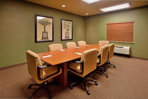 a conference room with a wooden table and chairs at Candlewood Suites St. Robert by IHG in Saint Robert