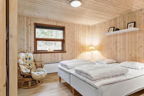 a bedroom with a bed and a chair and a window at TV1309-Bindslev-Ostervej-14 in Bindslev