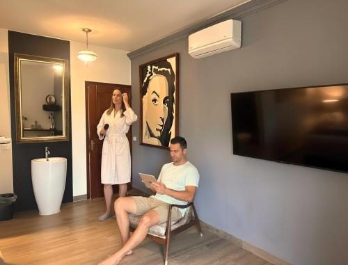 a man sitting in a chair in a room with a woman at Casa Chukum - Hotel Boutique in Bacalar