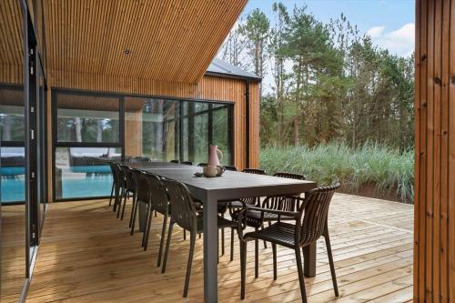 a dining room with a table and chairs on a deck at TV1572-Albaek-Lovevej-18 in Ålbæk