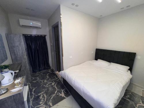 a bedroom with a large bed with a black headboard at Karnak temple pyramids view in Cairo