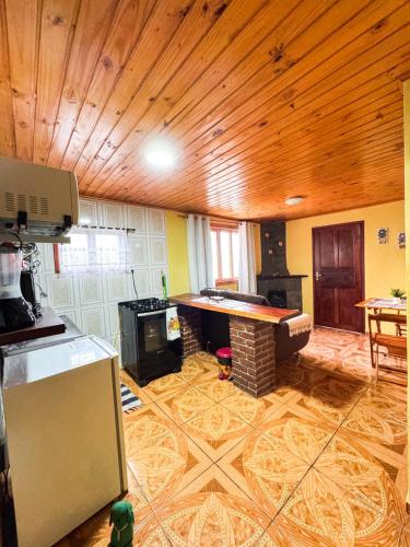 a living room with a wooden ceiling and a pool table at Chalés Cerejeira in Visconde De Maua