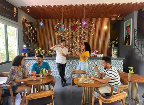 a group of people sitting at a bar in a restaurant at Casa Chukum - Hotel Boutique in Bacalar