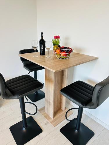 a table with two chairs and a table with wine glasses at KOMFORT FerienWohnung NeuBau Merzig in Merzig
