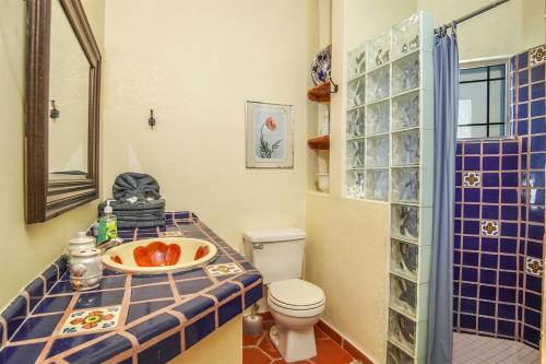 a bathroom with a toilet and a blue tiled counter at Casa L'italien in Oshawa