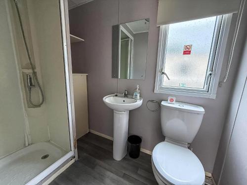 a small bathroom with a toilet and a sink at Superb 8 Berth Caravan At Highfield Grange Ref 26706Wr in Clacton-on-Sea