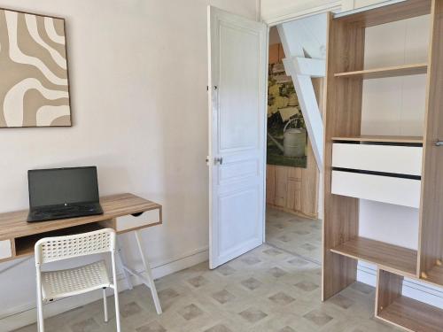 a room with a desk with a computer and a staircase at Logement cosy Le Margant pour 4 personnes in Guny
