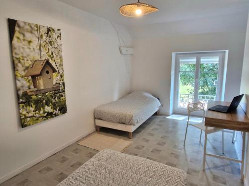 a living room with a desk and a chair at Logement cosy Le Margant pour 4 personnes in Guny
