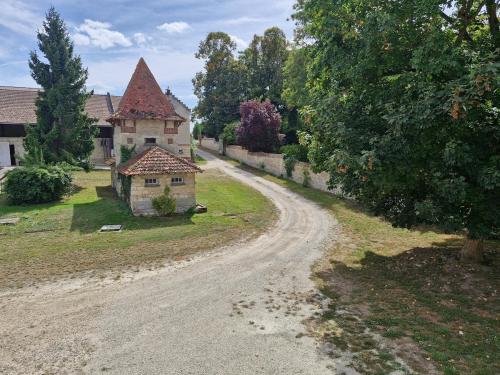 an old house on the side of a dirt road at Logement cosy Le Margant pour 4 personnes in Guny