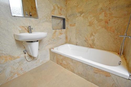 a bathroom with a sink and a bath tub and a sink at Aurobay Resorts Pondicherry in Auroville