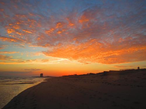 a sunset on a beach with the sun setting at Playa Encanto Scenic Gem Ocean Front Home in Playa Encanto