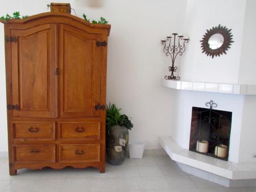 a room with a wooden cabinet and a fireplace at Playa Encanto Scenic Gem Ocean Front Home in Playa Encanto