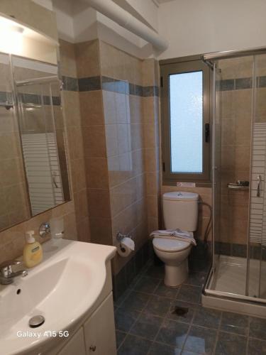 a bathroom with a sink and a toilet and a shower at Evangelia in Ayia Evfimia