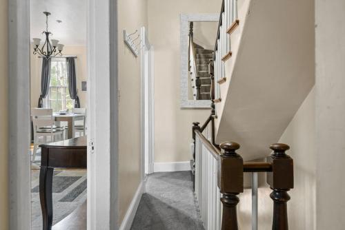 een hal met een trap, een tafel en een spiegel bij The 87th Townhome - Local Landmark Property in Portland