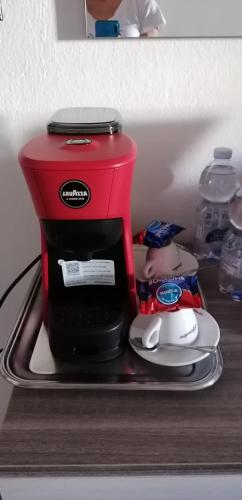 a red coffee maker sitting on top of a shelf at Mare&Vancanze in Quartu SantʼElena