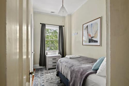 een kleine slaapkamer met een bed en een raam bij The 87th Townhome - Local Landmark Property in Portland