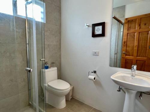 Un baño con inodoro, lavabo y ducha. en Casa Blanca Manuel Antonio A3, en Manuel Antonio