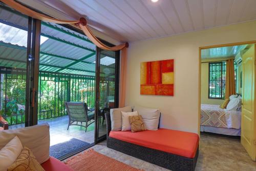 a living room with a red bench and a bedroom at Mono Vista At Jungle Creek Chill out in the Jungle in Manuel Antonio