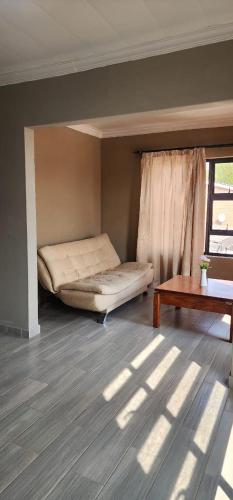 a room with a bed and a table and a window at Strictly Halaal Brand New Self Catering Apartment in Lenasia