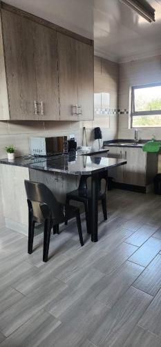 a large kitchen with a table in the middle of it at Strictly Halaal Brand New Self Catering Apartment in Lenasia