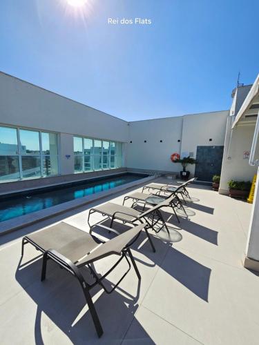 a row of chaise lounge chairs on the roof of a building at Flat Saint Moritz Express By Rei dos Flats in Brasilia