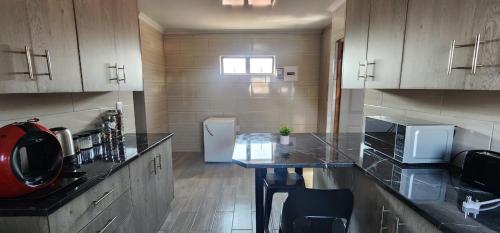 a kitchen with a counter and a refrigerator at Strictly Halaal Brand New Self Catering Apartment in Lenasia