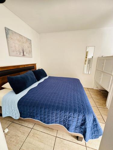 a bedroom with a blue comforter on a bed at MAKTVB Europa - Hostal Boutique in Santiago