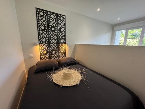 a bedroom with a bed with a black comforter at Appartement Caen proche Gare in Caen