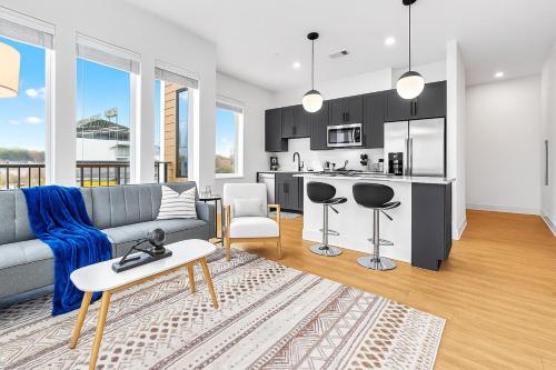 a living room with a couch and a kitchen at Luxury 2BR Steps from Railroad Park in Birmingham